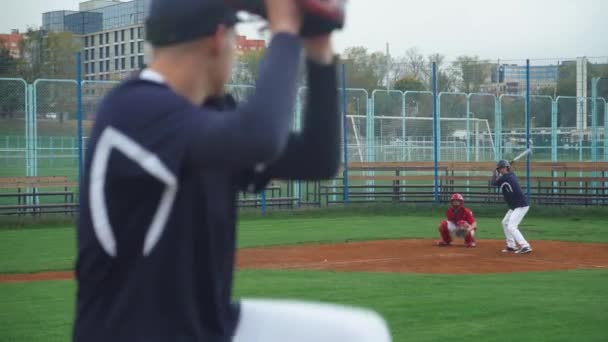 College sports, the pitcher throws the ball towards the batter, batter successfully hits fastball and run, 4k slow motion, back view. — Stock Video