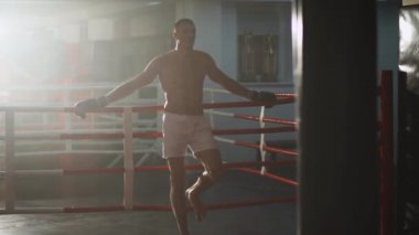 Kickboks, atletik adam boks antrenmanından sonra boks sahasının yanında duruyor, boks salonunda antrenman günü, sinema sahneleri..