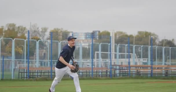 Turniej baseballowy, dwóch baseballistów przybija sobie piątkę po udanym meczu, miotacze bejsbolowi na stadionie, dzień treningu. — Wideo stockowe