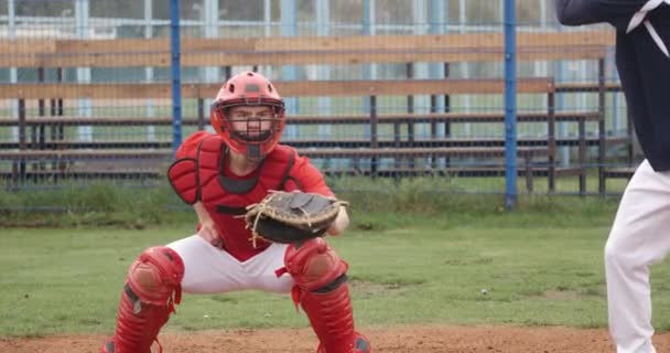 Partita di baseball al college, ricevitore prende una palla veloce e la lancia al lanciatore, giornata di allenamento. — Video Stock