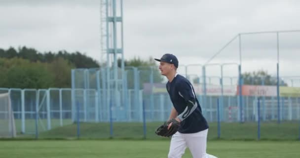 Baseballový turnaj, nadhazovač chytí rychlý míč a pošle přihrávku jinému hráči, sport na vysoké. — Stock video