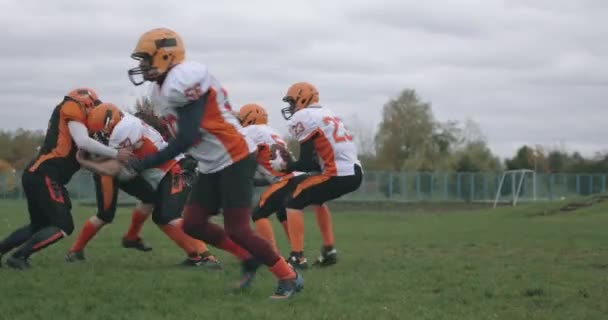 Football americano, squadra di calcio nel gioco, il giocatore prende palla e cade a terra, battaglia tra i giocatori in equipaggiamento protettivo, 4k 50fps. — Video Stock