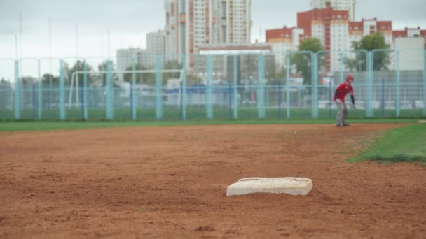 College, dzień treningu baseballa, łapacz i biegacz biegają po bazie, łapacz wyprzedza biegacza, chłopaki trenują do gry w baseball. — Wideo stockowe