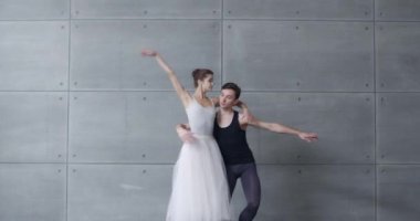 Gri arka planda dans provası yapan iki klasik balerin, bale dansçılarının romantik dansı, koreografiyle meşgul genç bir çift..