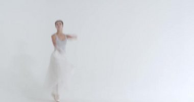 Beyaz etekli zarif bir kadın, bale yapıyor ve beyaz arka planda koreografik elementler sergiliyor..