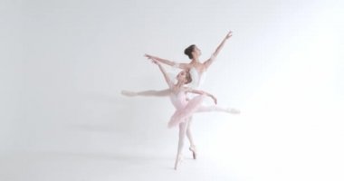 Beyaz etekli bir kadın ve küçük kız, bale yapıyor ve beyaz bir arka planda koreografik elementler sergiliyor..