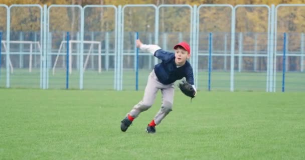 Baseball turnaj ve škole, chlapec nadhazovač běh a úspěšně chytí rychlý míč v rukavici, posílá přihrávku na jiného hráče, 4k zpomalení. — Stock video