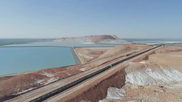 Mineração de sal de potássio, pilhas de sal vista aérea de pedreiras industriais, linha transportadora em poços de sal, vista de altura em colinas de areia, lodo e resíduos de mineração. — Vídeo de Stock