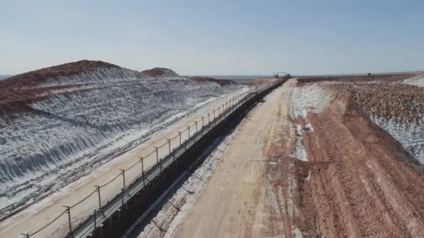 Minería de sal de potasa, línea transportadora en pozos de sal, vista aérea de pilas de sal y canteras industriales, vista desde la altura sobre colinas de arena, lodos y residuos mineros. — Vídeo de stock