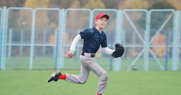 Honkbal toernooi op school, de jongen werper lopen en met succes vangt een fastball in de handschoen, jongen stuurt pass naar een andere speler, 4k slow motion. — Stockvideo