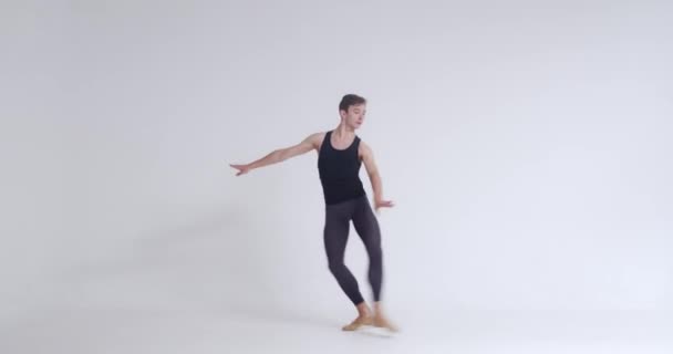 Elegante mannelijke, balletdanser voert acrobatische elementen en pirouette, ballet dans op een witte achtergrond, 4k 50fps. — Stockvideo