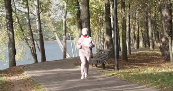 Bienestar, mujer adulta corriendo por un parque forestal, ejercicio aeróbico en el día de otoño. — Vídeo de stock