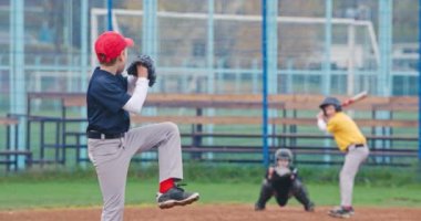 Okulda beyzbol turnuvası, beysbol oynayan çocuklar, atıcı topu bir vurucuya doğru fırlatıyor, vurucu başarılı bir şekilde hızlı topa vuruyor, 4k yavaş çekim..