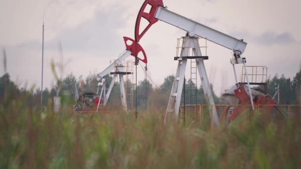 Добыча ресурсов и добыча нефти, нефтяные вышки на месторождении выкачивают нефть, топливо и нефтяную промышленность. — стоковое видео