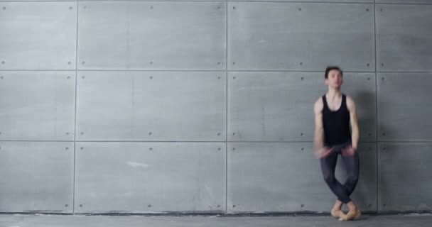 Elegantní samec, baletní tanečník provádí akrobatické prvky baletního tance na šedém pozadí, 4k pomalý pohyb. — Stock video