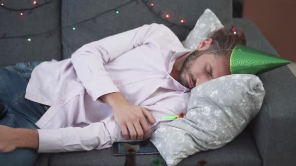 Fiesta en casa, el hombre duerme en el sofá en la sala de estar después de una fiesta de año nuevo, Navidad y Año Nuevo celebraciones. — Vídeos de Stock