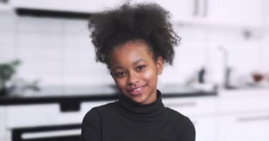 Geçmişi bulanık güzel bir Afrikalı kızın portresi, video blogcusu konuşuyor, gülüyor ve kameraya bakıyor, olumlu duygular, 450 fp.