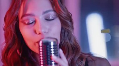 Bir gece kulübünde şarkı söyleyen genç bir kadının portresi, bir kadının yakın plan fotoğrafı, sahnede şarkı söyleyen bir şarkıcı..