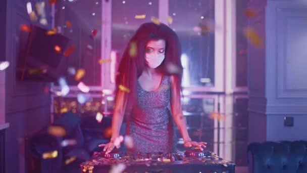 Роскошная вечеринка, гламурный ди-джей женщина в защитной маске танцует в ночном клубе, золотые конфетти летают в воздухе, неоновый свет, частная вечеринка во время пандемического, 4K замедленного действия. — стоковое видео