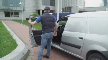 Kurye paketleri arabadan ofise taşır, arabadan kutuları alır ve müşteriye götürür, teslimat işlemi....