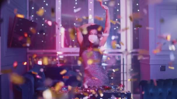 Luxury Party, glamour DJ female wearing protective mask dancing in the night club, golden confetti flying in the air, neon light, private party during the pandemic, 4k slow motion. — Stock Video