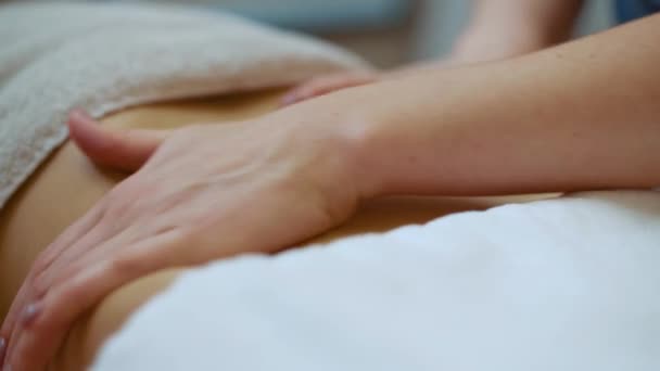 Спа массаж тела, профессиональный массажист делает расслабляющий массаж брюшной полости для молодой девушки, закрыть. — стоковое видео