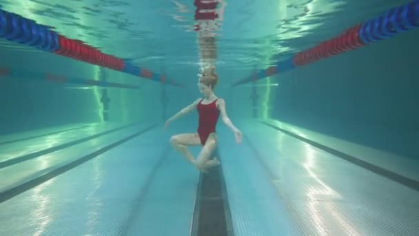 Ung kvinnlig simmare i poolen, ung kvinna utför inslag av synkroniserad simning, vacker dans under vatten. — Stockvideo