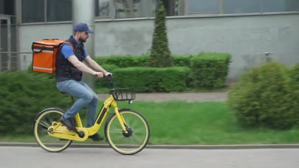 A termo hátizsákkal ellátott futár kerékpárral megy a vásárlóhoz, az élelmiszer szállításának folyamata. — Stock videók