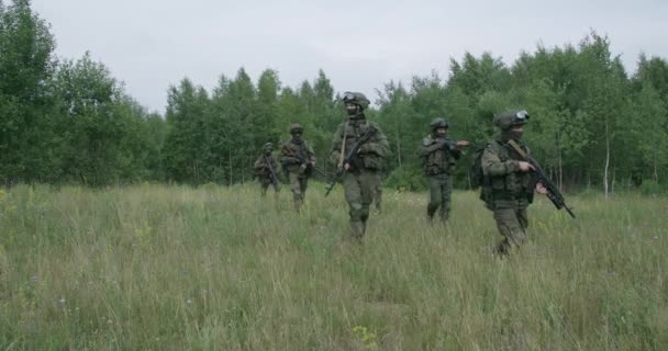 Soldados en camuflaje con rifle de asalto caminando por el campo de acción militar en el área de la estepa, 4k cámara lenta. — Vídeo de stock