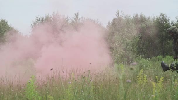 Soldaten evacueerden de gewonde soldaat in een brancard, een reddingsoperatie onder dekking, rookgordijn op het veld, slow motion. — Stockvideo