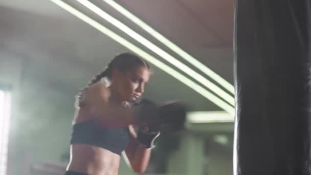 Boxing, woman fighter trains his punches, beats a punching bag, training day in the boxing gym, strength fit body, the girl strikes fast. — Stock Video