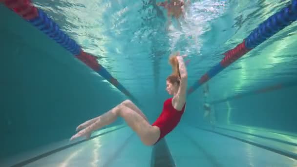 Hermosa nadadora femenina en la piscina, mujer joven realizar los elementos de la natación sincronizada, hermosa danza bajo el agua. — Vídeos de Stock