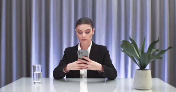 Empresária sentada à mesa e digitando texto no smartphone, comunicação na Internet, trabalho remoto. — Vídeo de Stock