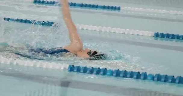 Молодая профессиональная женщина плавает на спине, пловец плавает в бассейне, женщина плавает и тренируется в бассейне, замедленное движение. — стоковое видео