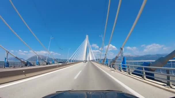 Viaje de verano por carretera en Europa, vista en primera persona de un automóvil en movimiento en un puente a través del estrecho, paseo cerca de los cruces de carreteras, vista del puente con cable. — Vídeo de stock