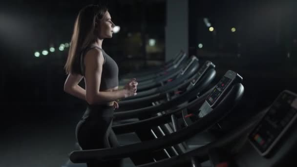 健康，年轻的女运动员在跑步机上跑步，有氧运动和耐力训练，夜生活，4k慢动作. — 图库视频影像