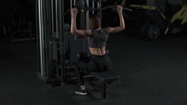 Spor salonundaki kadın kaldırma blokları raf makinesi, arka görüş, blok aygıtı ve spor aleti eğitimi, gece eğitimi, 450 fps.