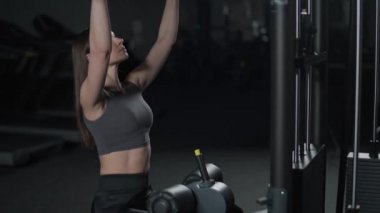 Spor salonunda kadın kaldırma blokları raf makinesinde, blok aygıtı ve spor aletleri üzerinde güç eğitimi, gece eğitimi, 450 fps.