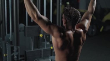 Spor salonundaki adam raf makinesinde kaldırma blokları, arka görüş, blok aygıtı ve spor aletleri eğitimi, gece eğitimi, 450 fps.