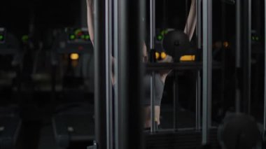 Spor salonunda kadın kaldırma blokları raf makinesinde, blok aygıtı ve spor aleti eğitimi, gece vakti, 4k ağır çekim.
