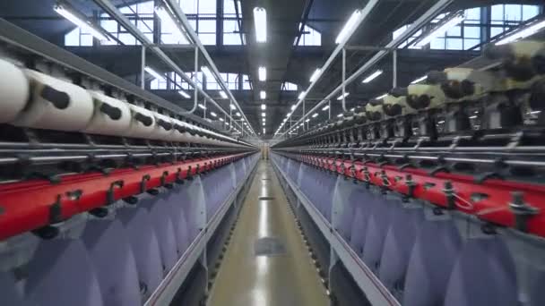 Spinnende fabriek, productie van stoffen, draad van zijde, linnen en synthetische stoffen, uitzicht op tunnels van de productielijn op de lichte industrie. — Stockvideo