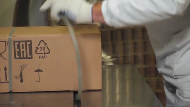 Produkcja artykułów spożywczych, praca pakowacza zamyka i pakuje kartonowe pudełko z gotowym produktem. — Wideo stockowe