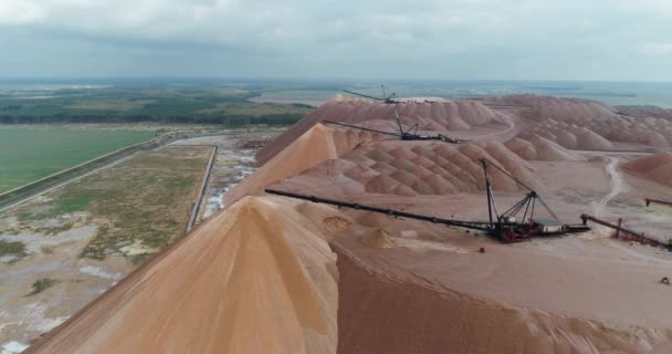 盐堆、工业采石场的航拍、盐坑中的输送机、盐矿开采、工作过程中的输送机线路、从高处看盐矿场. — 图库视频影像