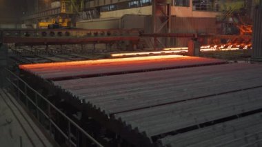 Çelik fabrikası, çelik çubuk ve boru üretimi, üretim hattıyla taşınan kırmızı sıcak borular, ağır sanayi, yuvarlanan metal fabrikası..