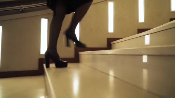 Jeune femme en haut des escaliers à l'hôtel, vue des pieds dans les chaussures, voyage d'affaires, caméra de suivi de mouvement. — Video