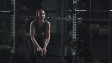 Sağlıklı yaşam tarzı, kadın dövüş halatlarıyla egzersiz yapıyor, spor salonunda dayanıklılık eğitimi alıyor..