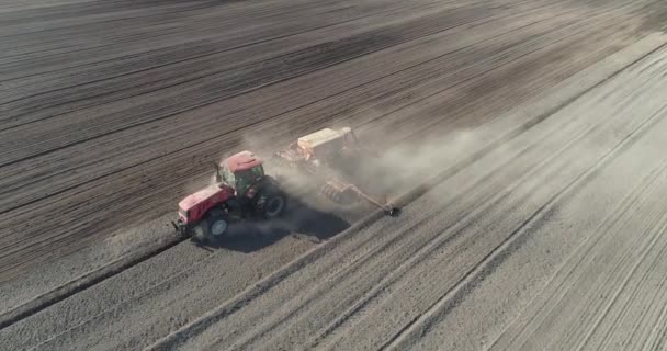 Vidék és mezőgazdaság, mezőgazdasági traktorok szántják a földet a mezőn, por a mezőn, kilátás a magasból. — Stock videók