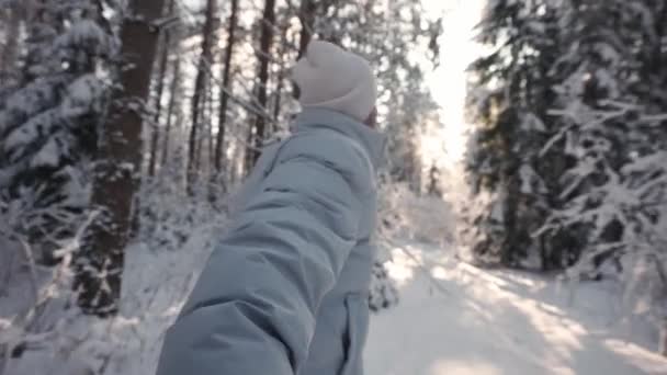 Chodź za mną, zimowy spacer przez las z mężczyzną, widok pierwszej osoby, człowiek trzymający się za rękę i prowadzi przez zimowy las w słoneczny dzień, punkt, 4k zwolniony ruch, niewyraźny widok. — Wideo stockowe