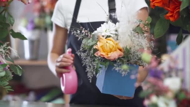 Florist hona samlar en bukett blommor i en låda, glad kvinna som arbetar i en blomma och växt butik, flerfärgad interiör. — Stockvideo