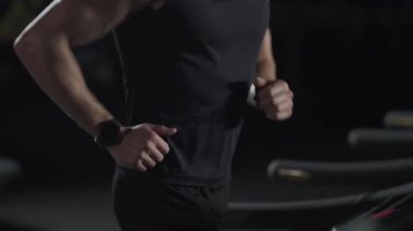 Sinema ışığı, koşu bandında koşan isimsiz bir adam, spor salonunda aerobik egzersiz ve dayanıklılık eğitimi..